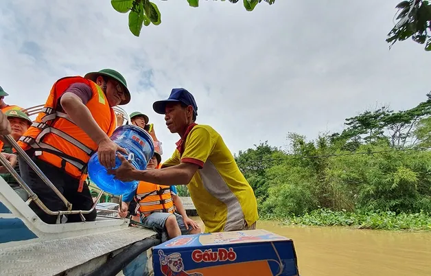 Đội ngũ cứu trợ trao nhu yếu phẩm cho người dân vùng lũ